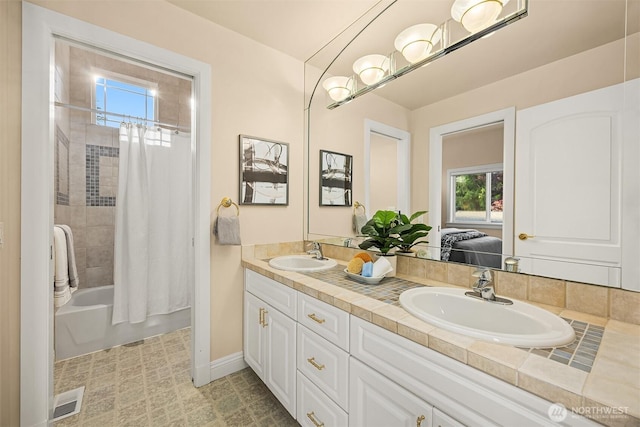 full bath featuring plenty of natural light, a sink, and double vanity