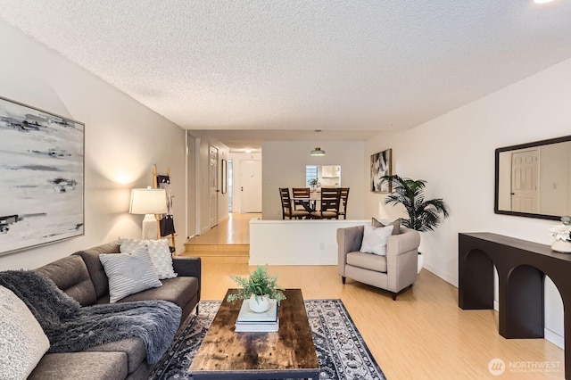 living area with a textured ceiling and light wood finished floors