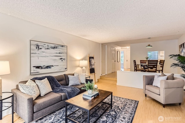 living area with a textured ceiling and light wood-style floors