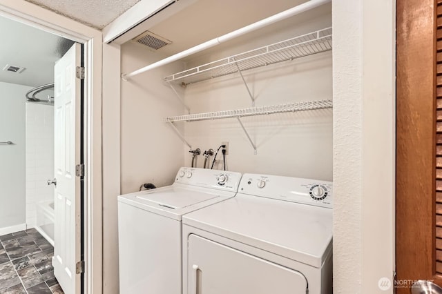 clothes washing area featuring washer and dryer, baseboards, laundry area, and visible vents