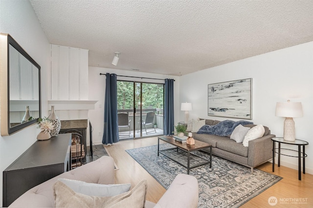 3518 109th Pl NE Unit 223, Bellevue, WA 98004 - living room with wood finished floors, a textured ceiling, and a fireplace