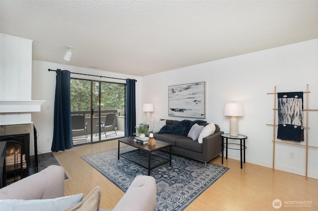 3518 109th Pl NE Unit 223, Bellevue, WA 98004 - living room featuring wood finished floors, a fireplace, and a textured ceiling