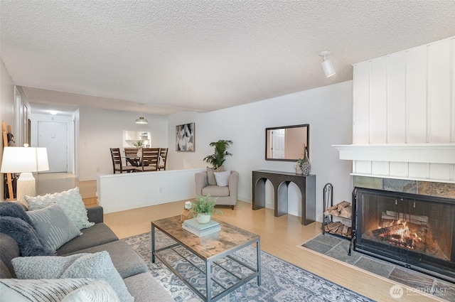 3518 109th Pl NE Unit 223, Bellevue, WA 98004 - living area featuring wood finished floors, a fireplace, and a textured ceiling
