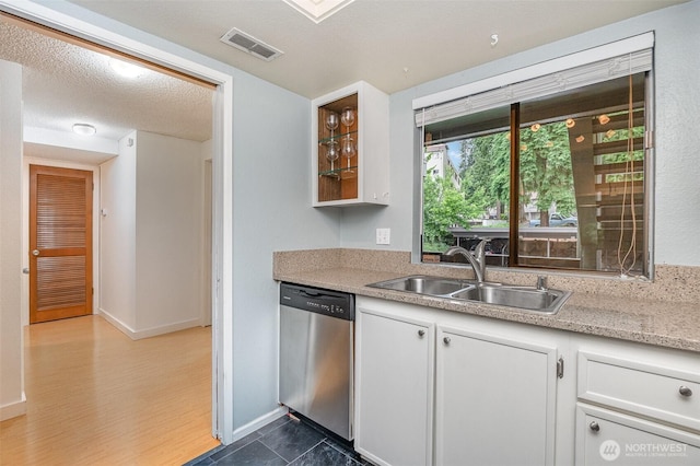 3518 109th Pl NE Unit 223, Bellevue, WA 98004 - kitchen featuring stainless steel dishwasher, white cabinetry, light countertops, and glass insert cabinets