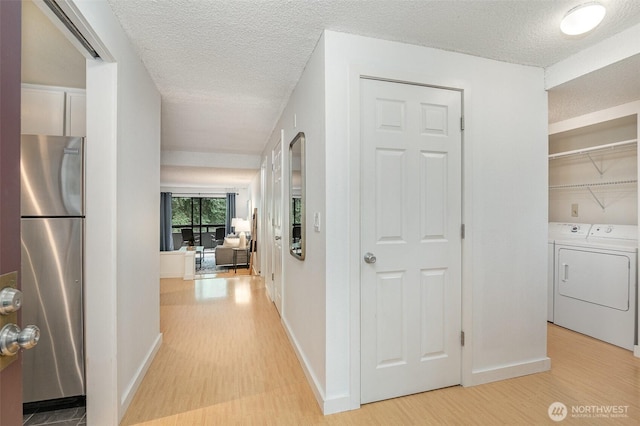 3518 109th Pl NE Unit 223, Bellevue, WA 98004 - corridor featuring light wood-type flooring, a textured ceiling, and washing machine and clothes dryer