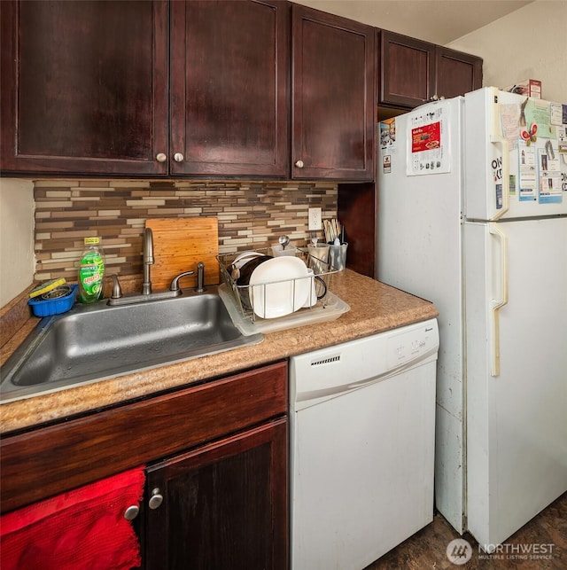kitchen with dark brown cabinetry, a sink, white appliances, light countertops, and tasteful backsplash
