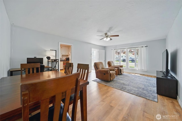 dining area featuring baseboards, ceiling fan, and light wood-type flooring