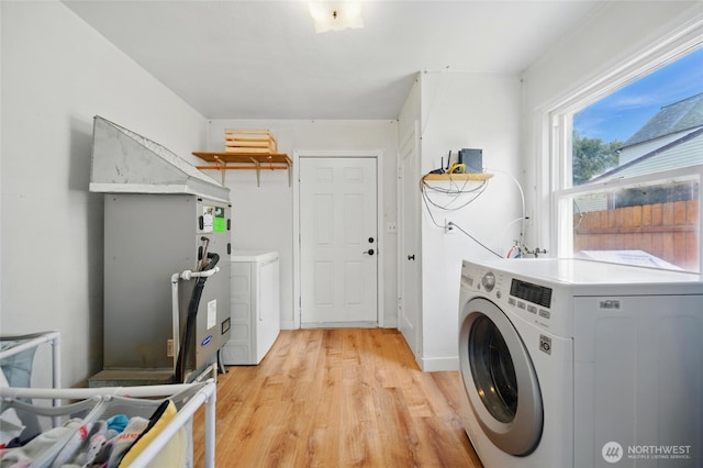 washroom featuring laundry area, washer and clothes dryer, and light wood finished floors