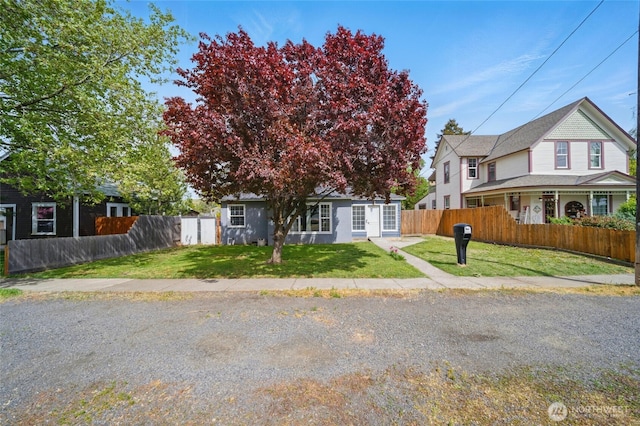 view of front of property featuring fence and a front lawn