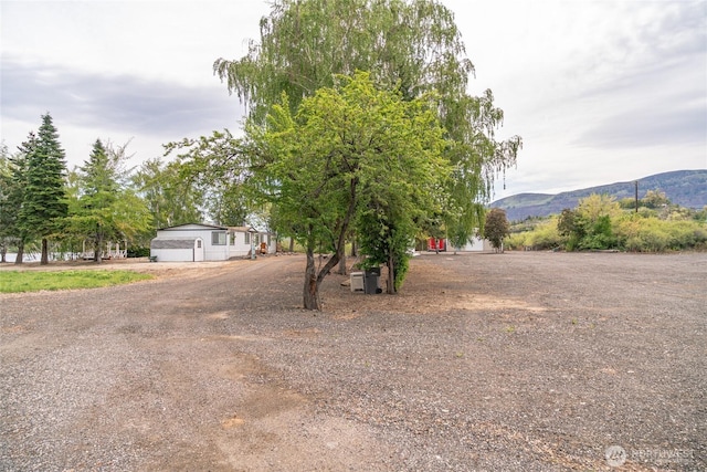 view of front facade with a mountain view and dirt driveway