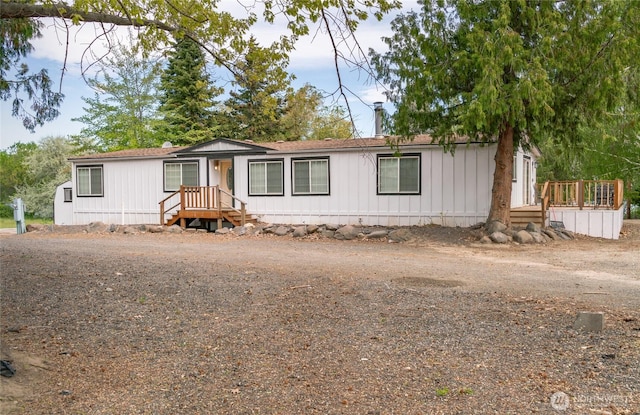 manufactured / mobile home featuring a shingled roof and a chimney