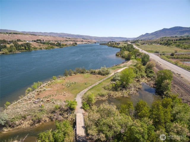 drone / aerial view featuring a water and mountain view