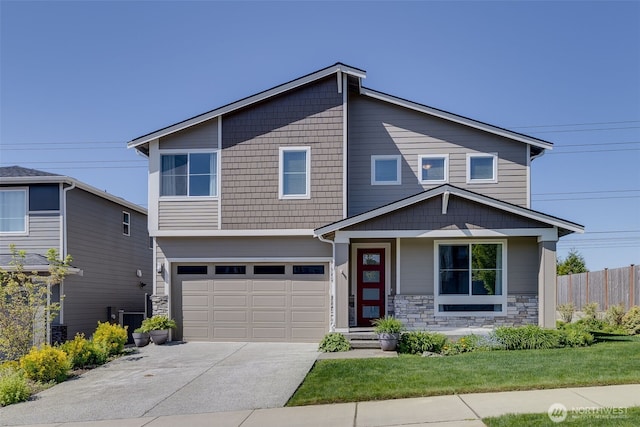 view of front facade featuring fence, concrete driveway, a garage, and stone siding