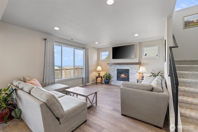 living area with recessed lighting, a fireplace, stairs, and a wealth of natural light