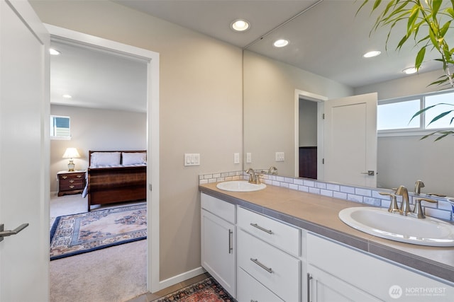 full bath featuring double vanity, a sink, ensuite bath, and recessed lighting