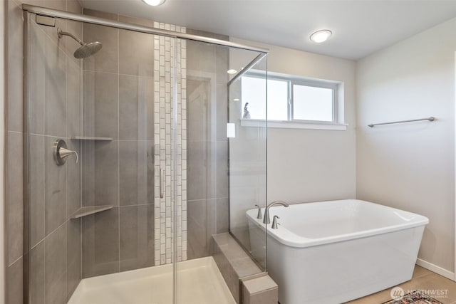 bathroom with a stall shower and a freestanding bath