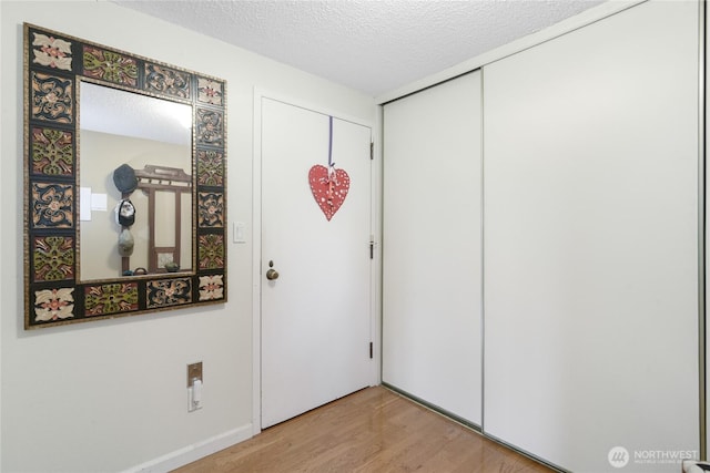 foyer entrance featuring a textured ceiling and light wood finished floors