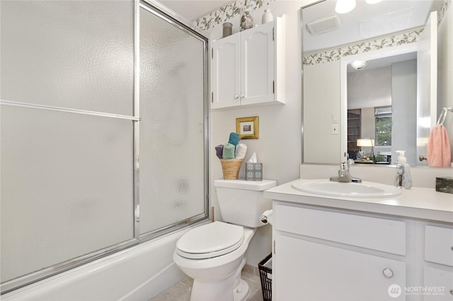 bathroom featuring toilet, shower / bath combination with glass door, and vanity