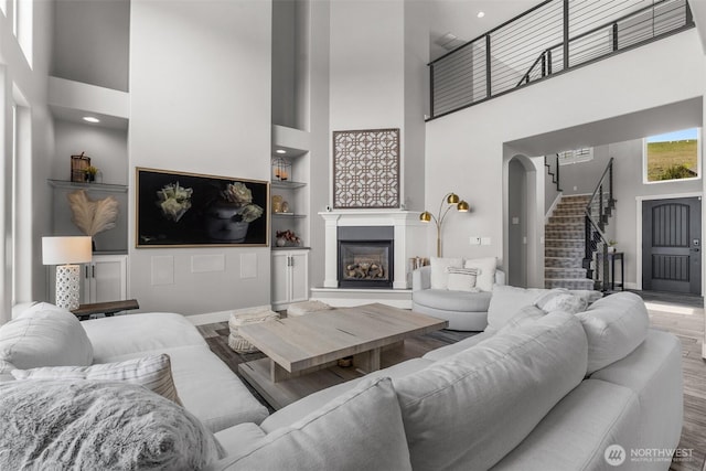 1614 W 51st Ave, Kennewick, WA 99337 - living area featuring a glass covered fireplace, built in shelves, a high ceiling, and stairway
