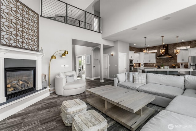 1614 W 51st Ave, Kennewick, WA 99337 - living area featuring dark wood-style flooring, a glass covered fireplace, baseboards, a high ceiling, and recessed lighting