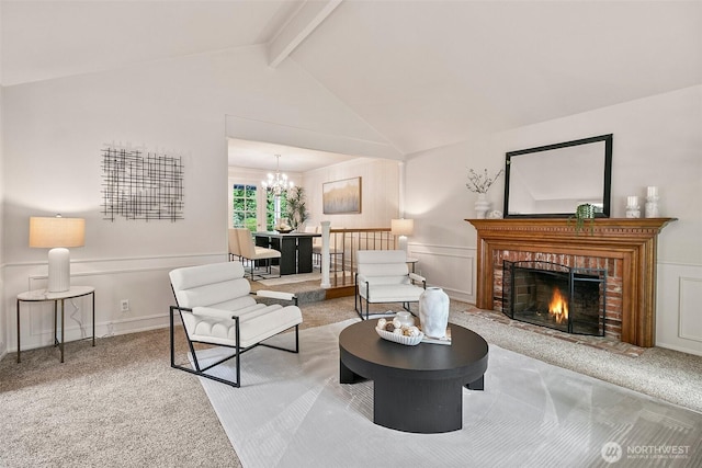 carpeted living room featuring wainscoting, a brick fireplace, lofted ceiling with beams, a chandelier, and a decorative wall