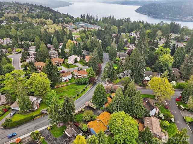 birds eye view of property featuring a residential view, a water view, and a forest view