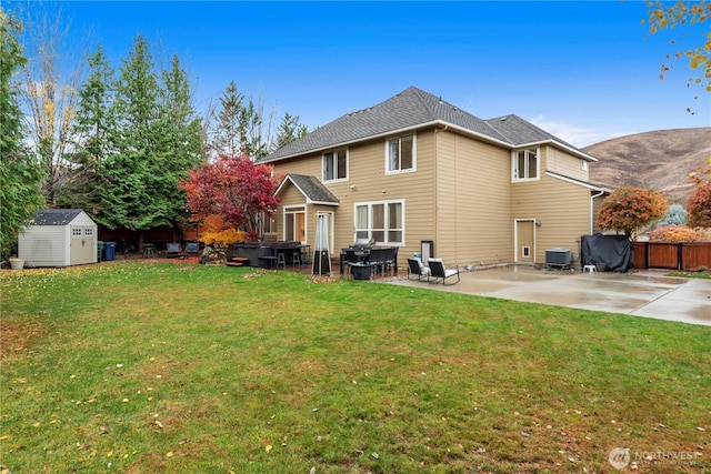 back of house with fence, a patio, a storage unit, central air condition unit, and an outbuilding