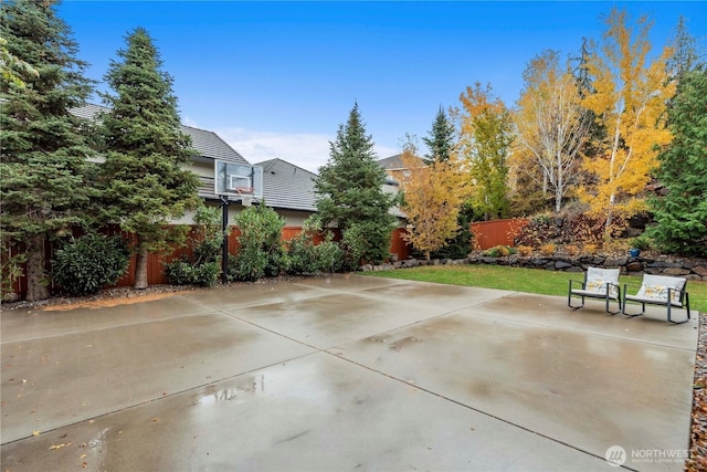 view of patio / terrace featuring a fenced backyard and basketball hoop