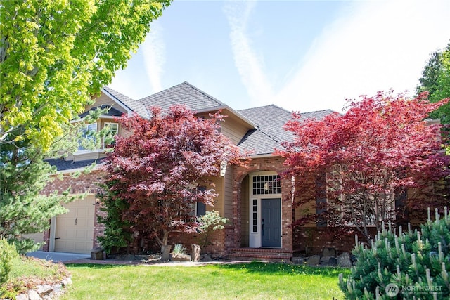 view of front of home with brick siding, a front lawn, and roof with shingles