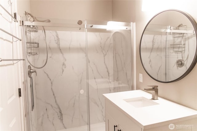 full bath with a marble finish shower and vanity