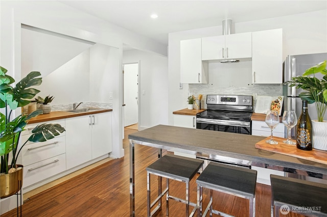 3003 E Pine St, Seattle, WA 98122 - kitchen with electric stove, a sink, white cabinets, backsplash, and recessed lighting