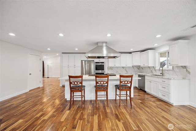 18 SE 18th St, Battle Ground, WA 98604 - kitchen featuring stainless steel appliances, a sink, wood finished floors, tasteful backsplash, and a breakfast bar