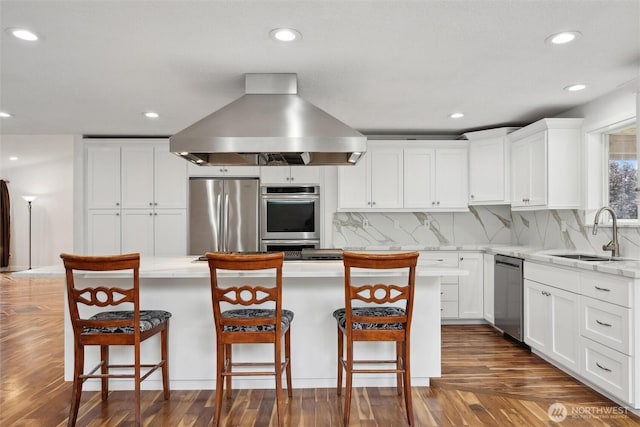 18 SE 18th St, Battle Ground, WA 98604 - kitchen featuring appliances with stainless steel finishes, a sink, island range hood, dark wood-type flooring, and decorative backsplash