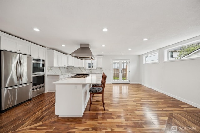 18 SE 18th St, Battle Ground, WA 98604 - kitchen with stainless steel appliances, ventilation hood, wood finished floors, white cabinetry, and recessed lighting