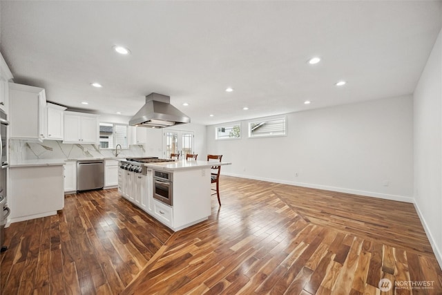 18 SE 18th St, Battle Ground, WA 98604 - kitchen with appliances with stainless steel finishes, island range hood, a kitchen bar, plenty of natural light, and recessed lighting