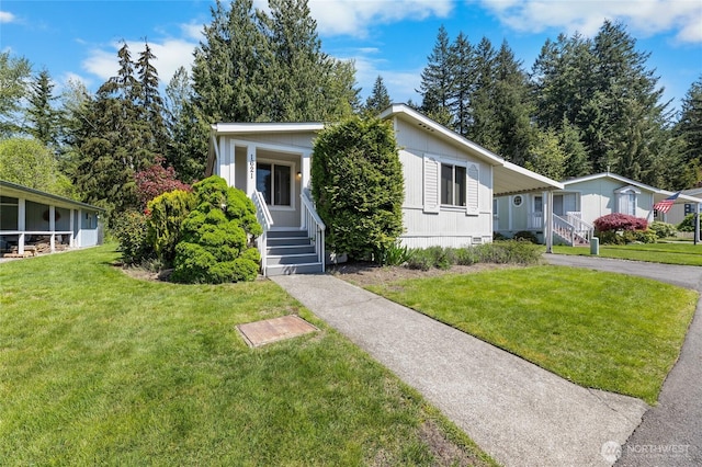 view of front of house featuring an attached carport, driveway, and a front yard