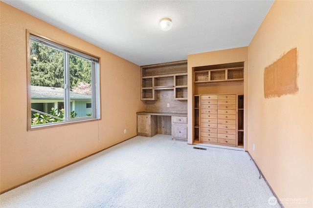 unfurnished office with baseboards, visible vents, and carpet
