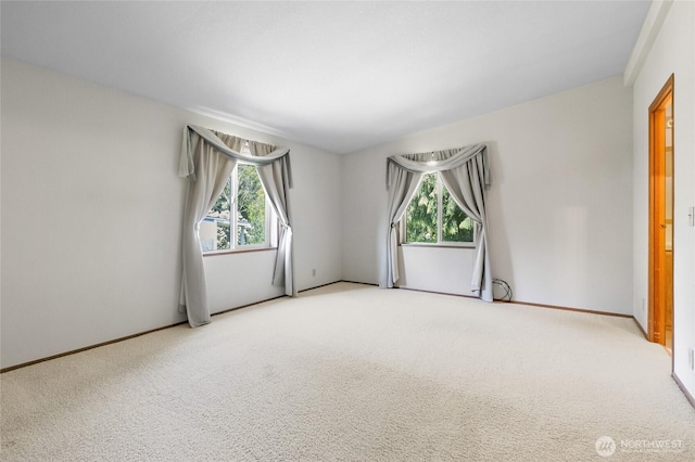 empty room featuring carpet flooring and baseboards