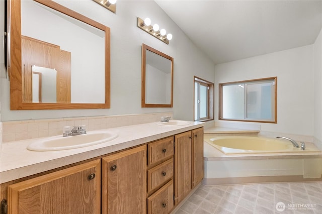 full bathroom featuring a sink, a garden tub, and double vanity