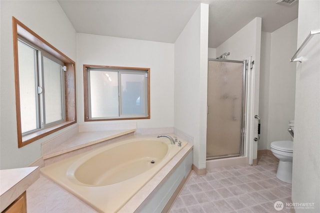 bathroom with a garden tub, toilet, and a shower stall