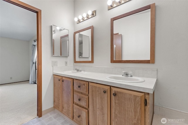 full bathroom with a sink and double vanity