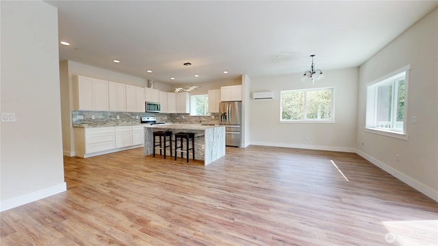 15941 Glenwood Rd SW, Port Orchard, WA 98367 - kitchen with decorative backsplash, appliances with stainless steel finishes, baseboards, a notable chandelier, and white cabinetry