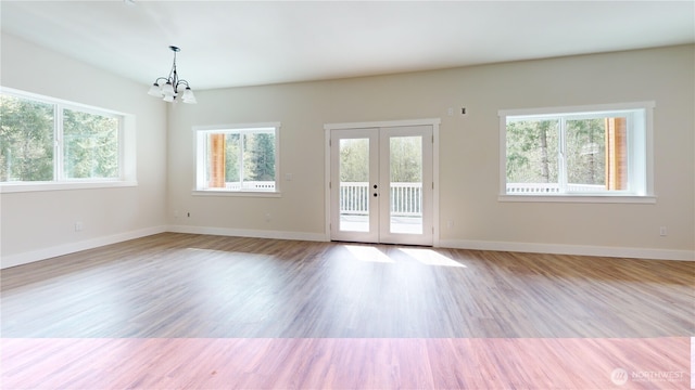 15941 Glenwood Rd SW, Port Orchard, WA 98367 - empty room with an inviting chandelier, baseboards, wood finished floors, and french doors