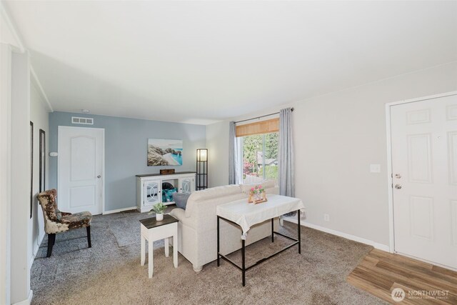 living room featuring visible vents, baseboards, and light wood-type flooring