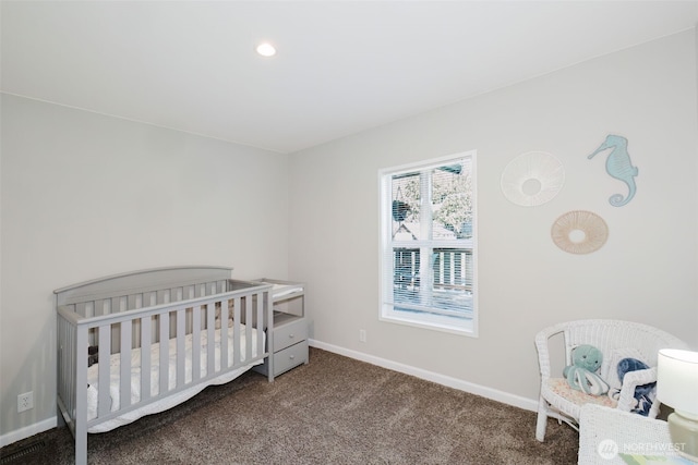 carpeted bedroom featuring baseboards and a nursery area