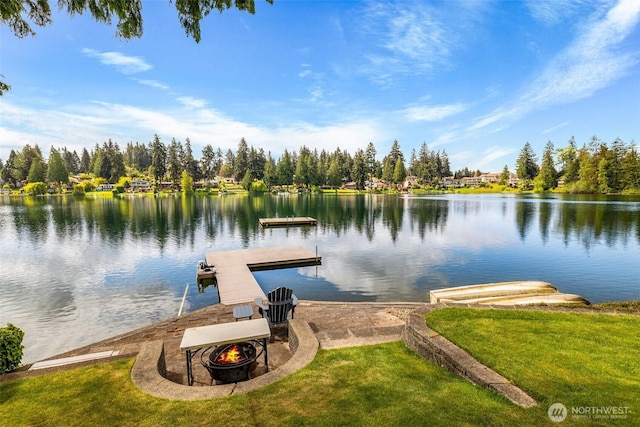 dock area with a water view, a yard, and an outdoor fire pit