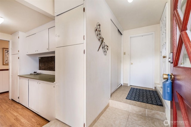 interior space with white cabinetry and light tile patterned floors