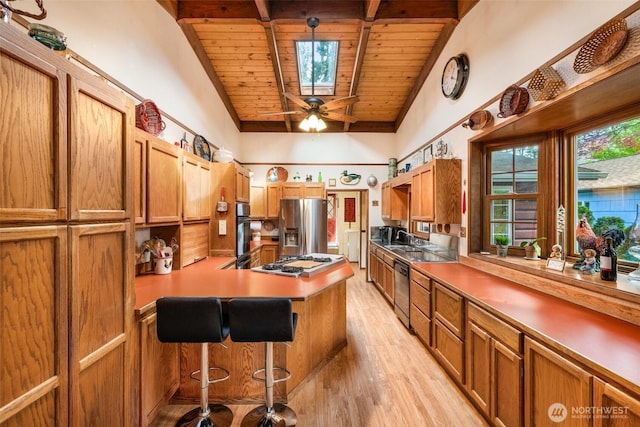 kitchen with a peninsula, black oven, white gas stovetop, wooden ceiling, and light wood finished floors