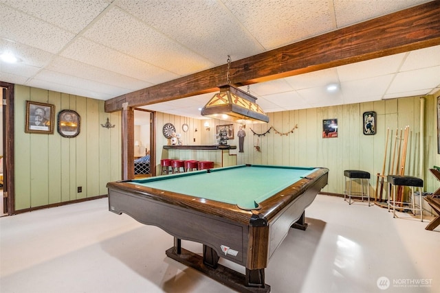 game room featuring a drop ceiling, pool table, wooden walls, and beamed ceiling