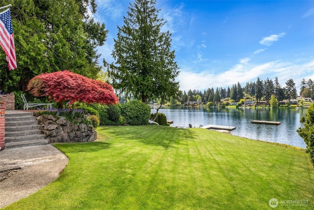 view of yard featuring a water view and a dock